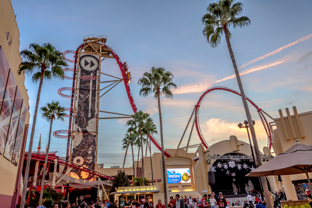 The tall 17 story incline of rip rockit stands vertically straight and loops against a sunset sky. 
