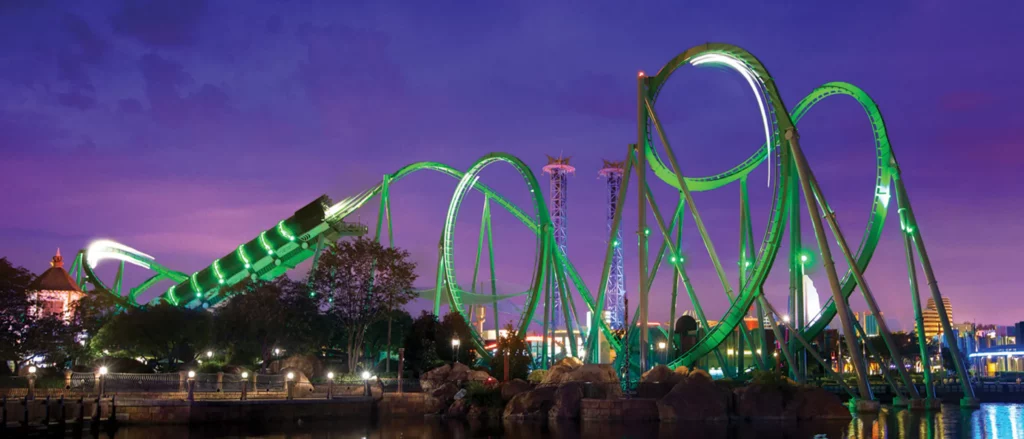 During the sunset, the Incredible Hulk Coaster and its green track lights up against the purple sky: this is one of best rides in Orlando theme parks.