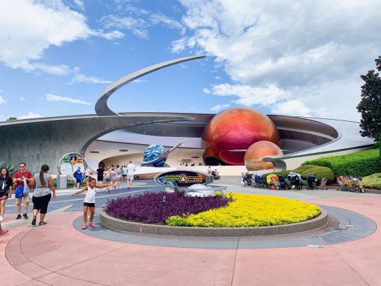 People walk by the front area of Mission Space: the planets and surrounded by spaceships: just choose a mission that is best fit for you! 