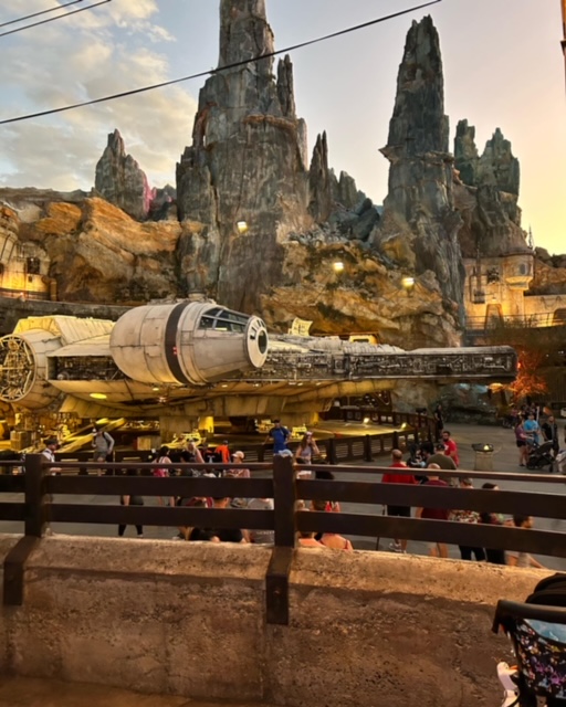 mountains in the background with giant spaceship (the millennium falcon) in front of it
