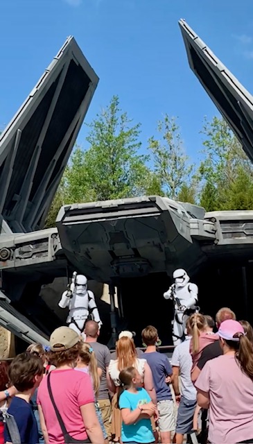 two white stormtroopers on stage in front of futuristic spaceship with audience watching Hollywood studios for adults 