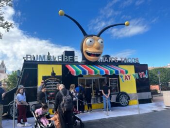 exterior of a restaurant at universal orlando featuring a giant bumble bee head on top of a black food truck