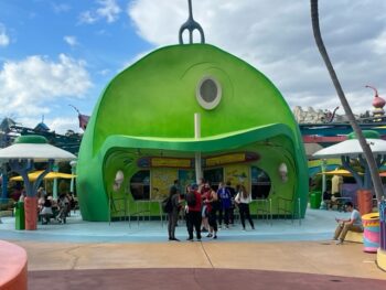 green building housing quick service restaurant at universal orlando with people standing outside of it