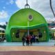 green building housing quick service restaurant at universal orlando with people standing outside of it