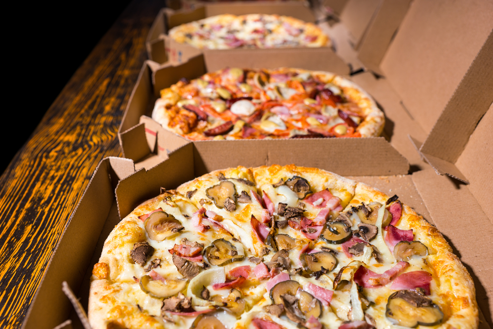 Pizza in boxes line upon a table: Louie's at Universal Orlando offers by the slice deals, and whole pies for the family. 