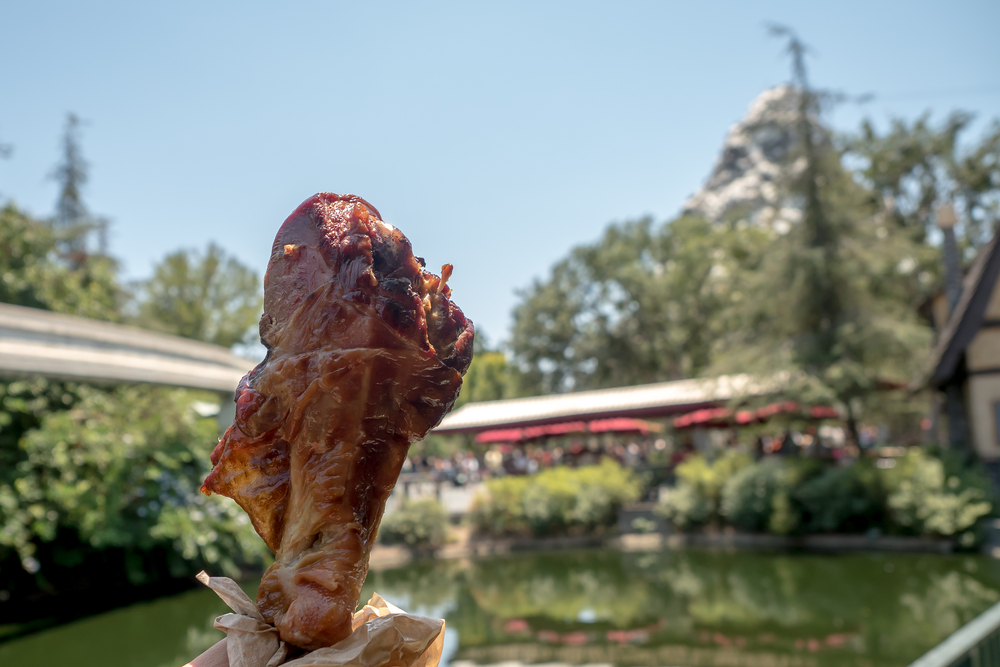 A guest holds up a giant turkey leg, showing off all the options of Universal Orlando Quick Service.