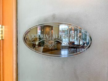 silver plaque on frosted glass with sign for Victoria & Albert's hard to get disney dining reservation