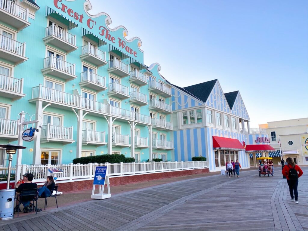 boardwalk with large white and teal vintage style hotel 