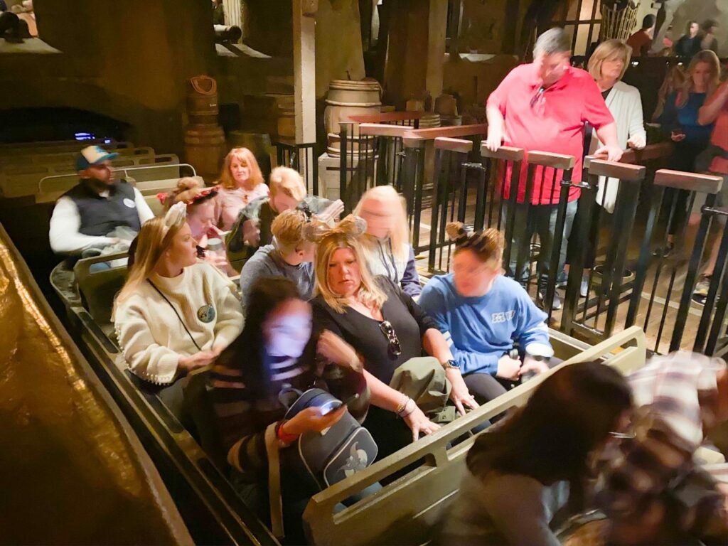Guests gather on a ride, their bags in their laps, and ears on their head, keeping their packed belongings with them.