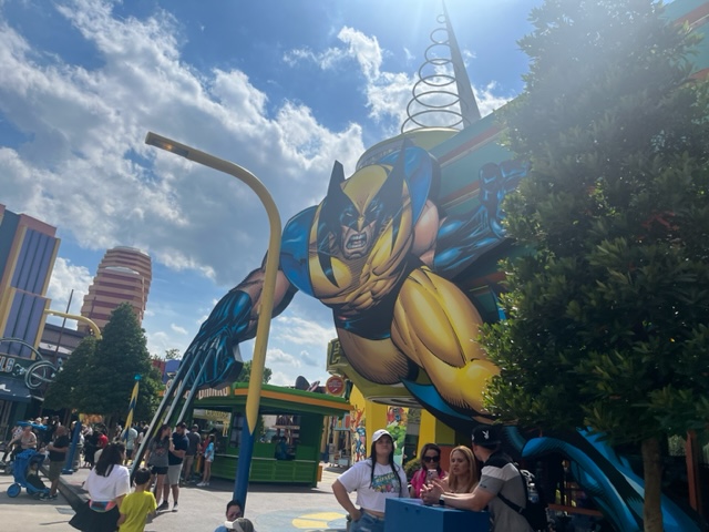 The comic design of Wolverine hovers over the people walking through Superhero Land.