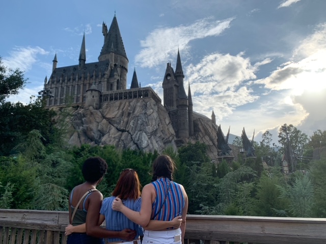 Three young girls admire Hogwarts from a bridge, knowing many of the Universal Orlando secrets. 