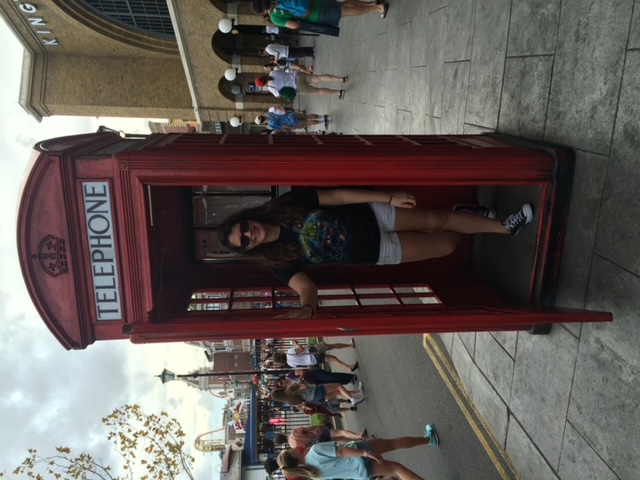 A girl stands in the red telephone booth in front of Kings Cross and Diagon Alley after dialing the ministry of magic. 