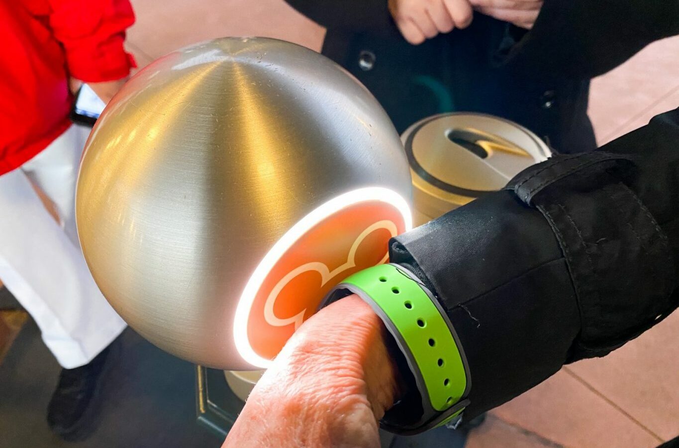 arm wearing green band scanning into disney at turnstile