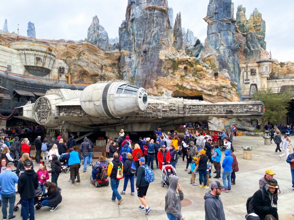 crowd of people in front of giant millennium falcon spaceship at disney without a park hopper