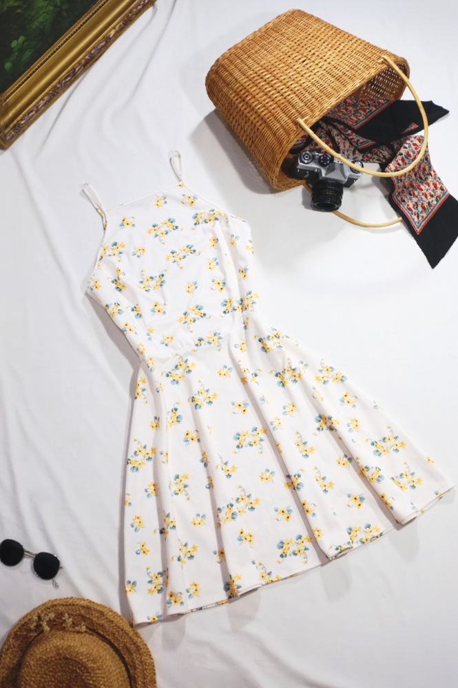 white and yellow floral sundress, straw bag with camera, and black sunglasses what to wear in disney in spring