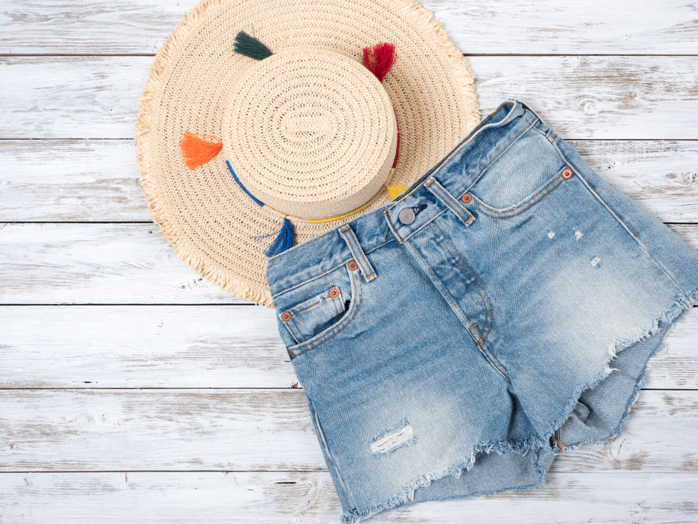 light blue jean cutoff shorts and light colored straw hat what to wear in Disney in spring