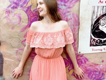 woman in peach dress against colorful purple painted wall