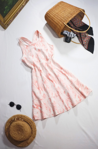 white and pink summer sundress flat lay with straw hat, sunglasses, and straw bag what to wear in disney in summer 