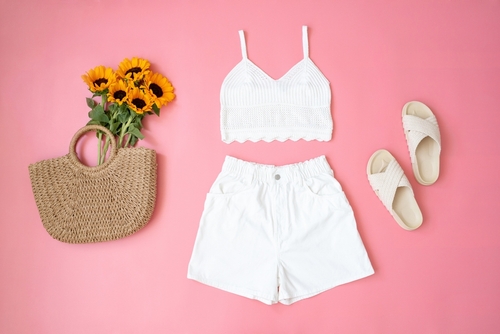 white short set flatly with white sandals and straw bag with pink background what to wear in disney in summer 