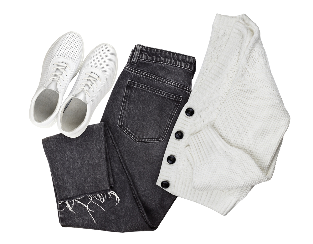 flatlay of white cardigan, white sneakers and black jeans disney outfit ideas for mom 