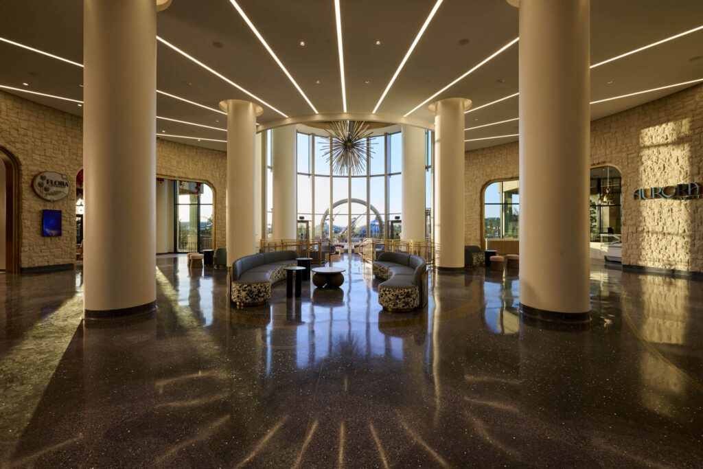 The open lobby feels Mediterranean and bright in Helios, making it stand out in its Epic Universe's hotels list due to the sun, the pillars, and the open windows.