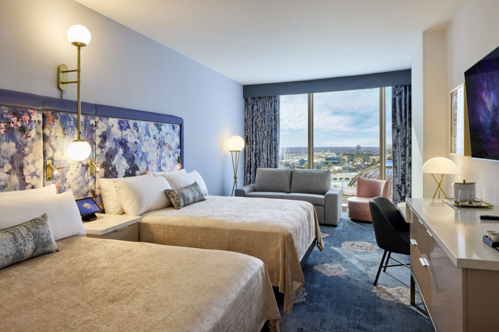 A suite at Helios features comfortable carpet, open windows overlooking Epic, patterned headboards and two beds!