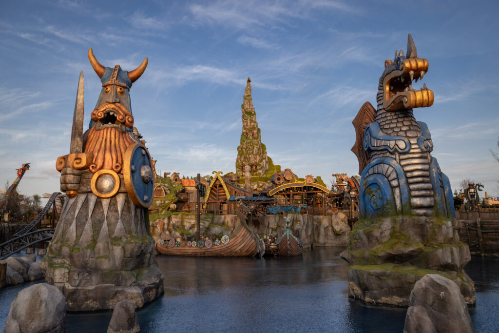 A photo of Isle of Berk welcomes you to the vikings with a pond, boats and statues.