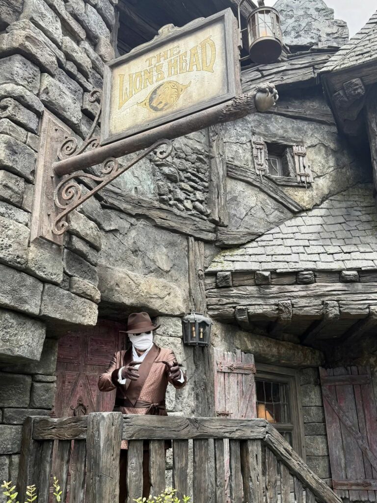When considering your Epic Universe packing list, consider themes, like how the Invisible Man in this photo stands at the Lions head, dark and mysterious.