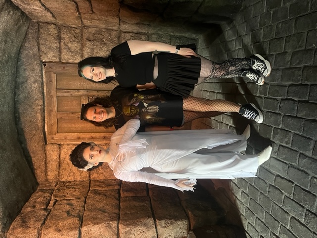 Two girls stand with the bride of Frankenstein, ready to pose with her!