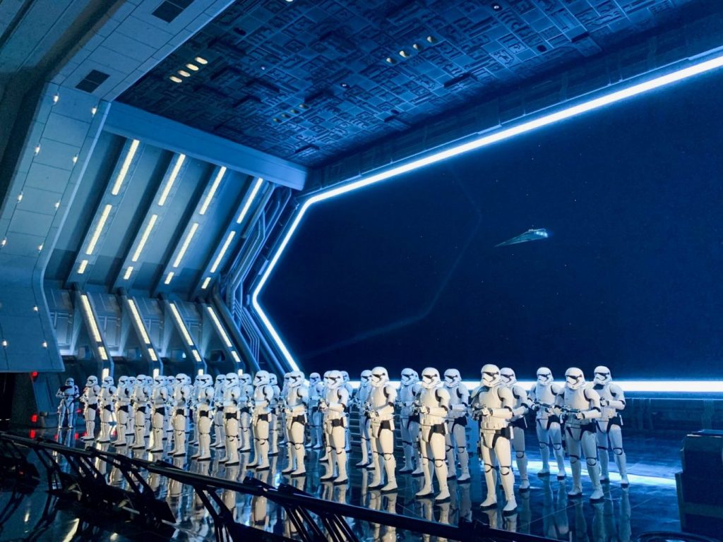 Inside Galaxy's Edge, on a ride, stormtroopers gather in lines with their weapons: knowing what Things People Forget When Packing for Disney World  will prep you for rides like this! 