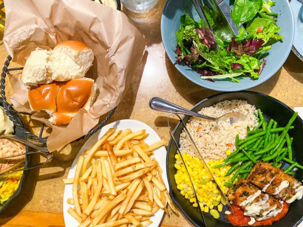 table with rolls, fries, salad, and vegetables at garden grill dinner