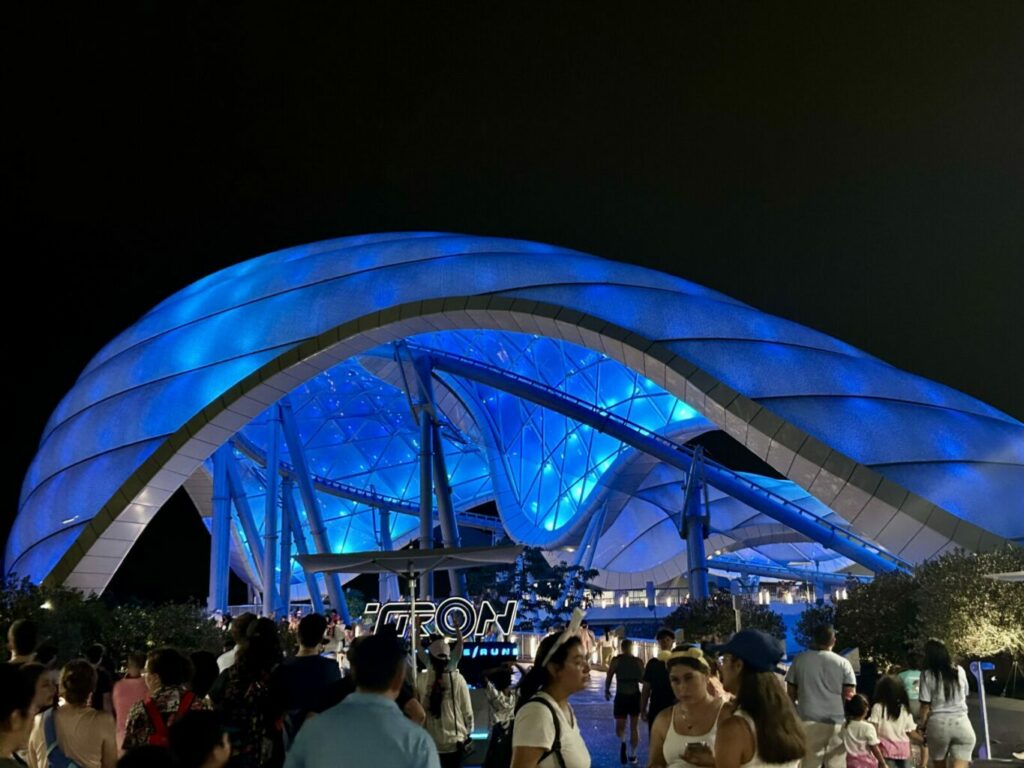 large lit up blue cover over ride and crowd in front of it